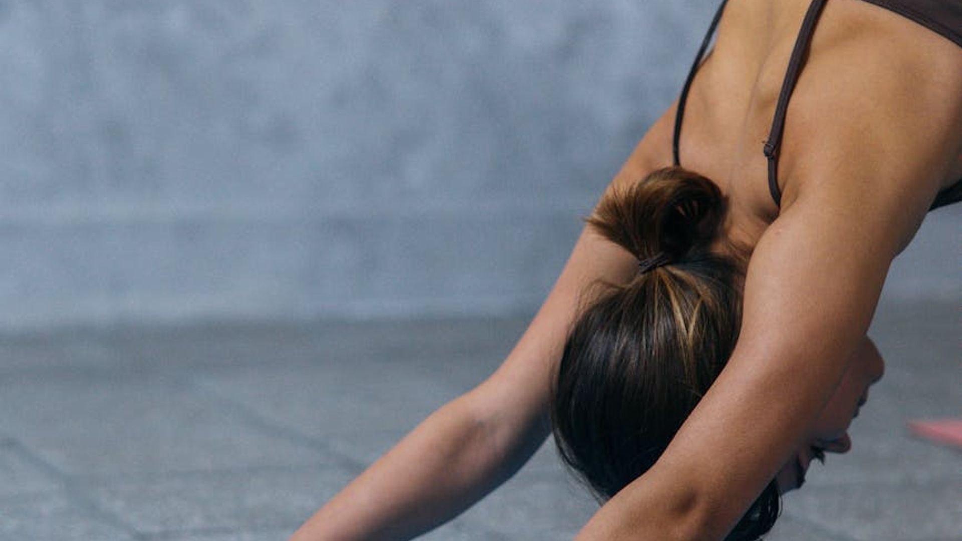 Person practicing calm yoga movements in dark studio environment